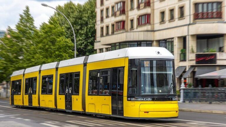 חשמלית צהובה יורדת בסמטה צרה בין בתים ישנים בליסבון